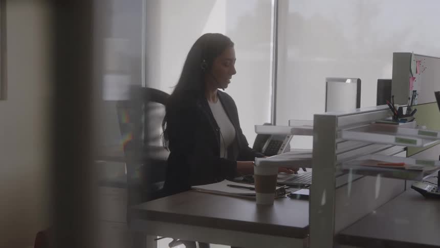 A woman in an office typing on her laptop