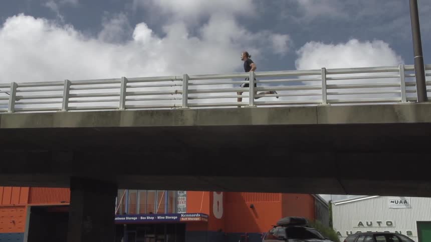 View of a man running across a small bridge