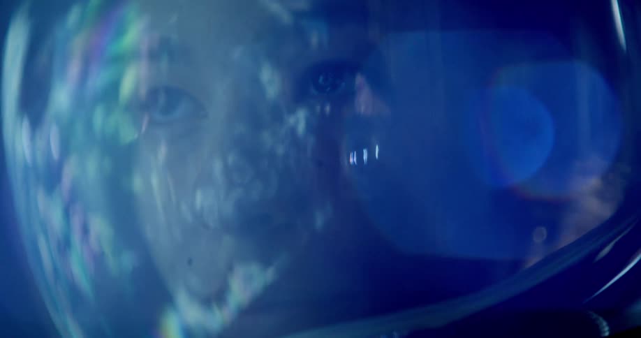A woman in a science fiction movie has a space helmet on her head