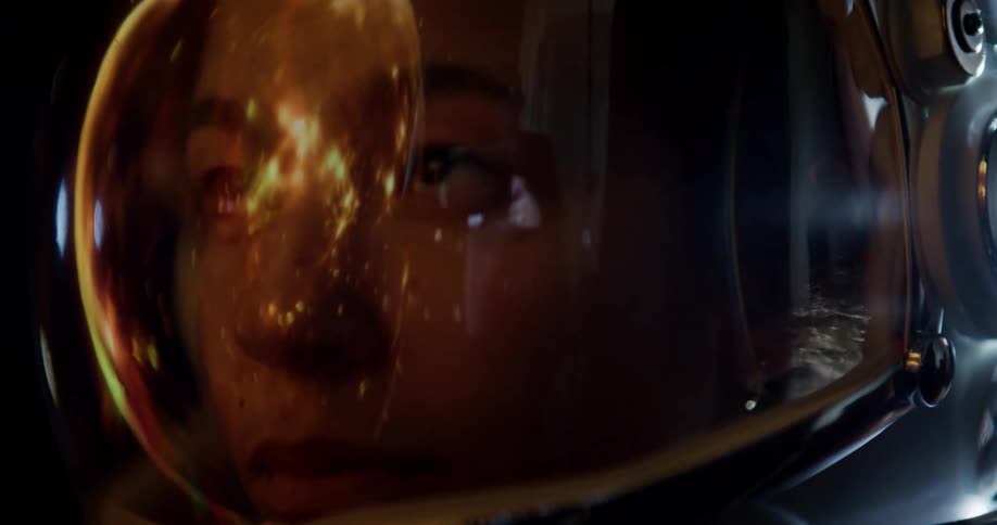 A close up shot of an astronaut with an orange reflection in the visor