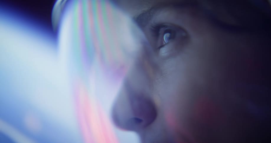 Focused gaze of a person reflected in a visor illuminated by bluish light