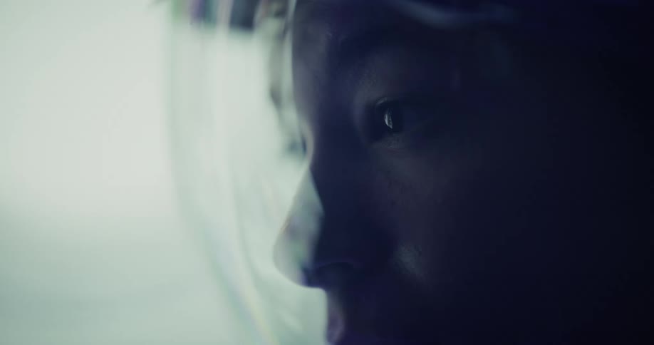 Astronaut gazes at the horizon through the helmet under diffused light