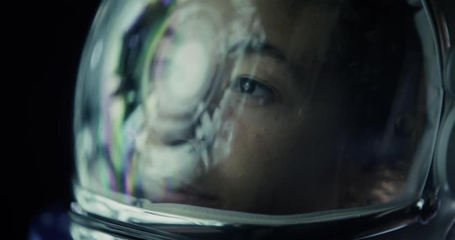 Astronaut gazes through the visor with colorful reflections and a contemplative look