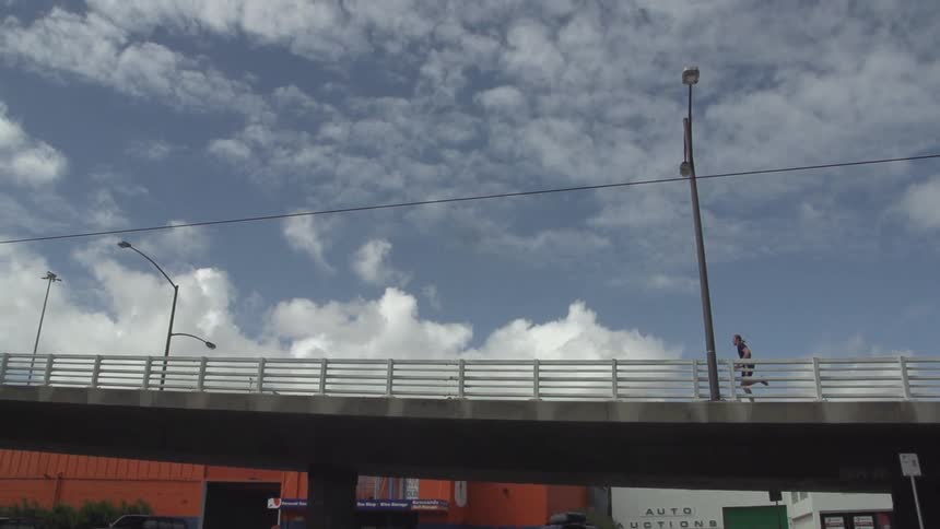 Man running across a bridge in the city