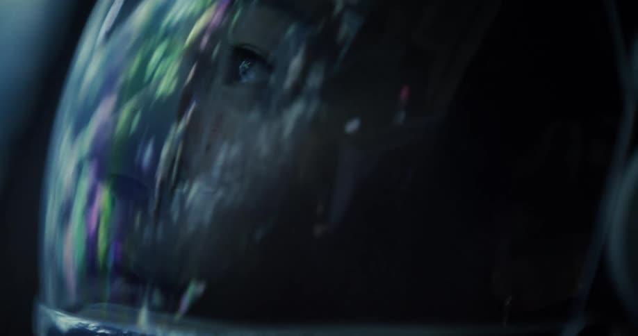 A person wearing a space helmet with a reflective visor floats in the dark expanse of space