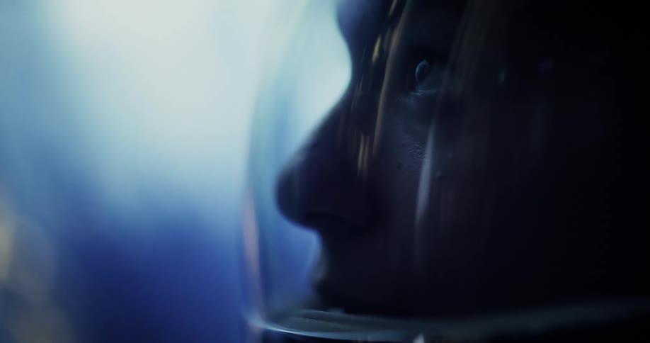 A woman in a space suit is floating in space above a planet