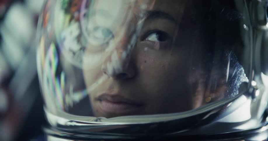A woman in a space suit floating in a spaceship