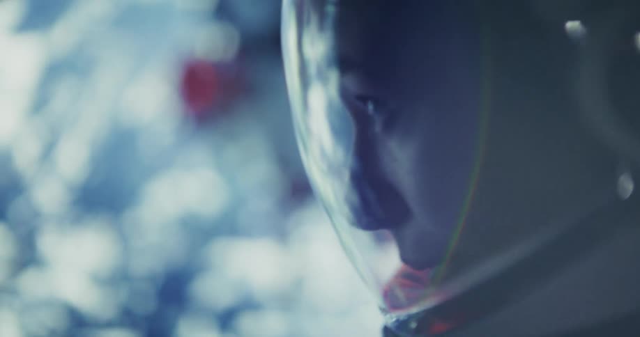 A close up profile shot of an astronaut against a soft focus blue planet.