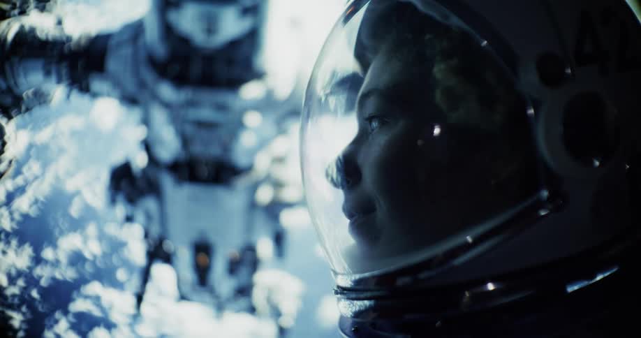 Sunlight flares the lens as an astronaut gazes up at a space station