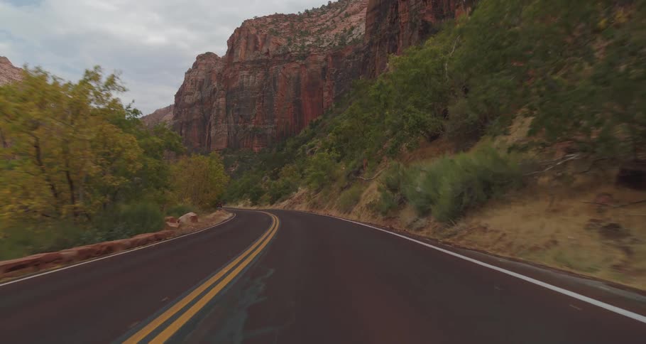 Other vehicles and people are seen as a vehicle makes its way through a moutain pass