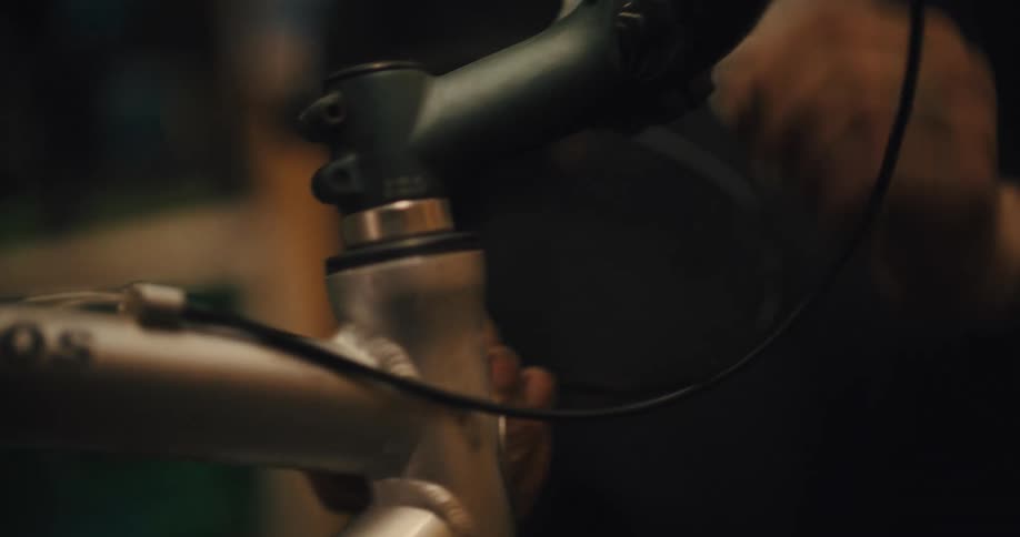 Extreme close up of a head tube and handlebars of a bicycle as a mechanic works on it
