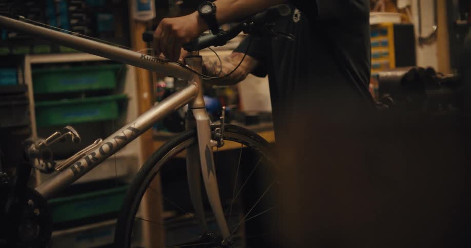 A close up of a mechanic working on a bicycle