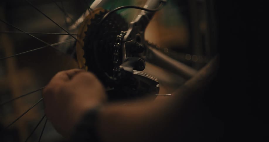 Hand adjusts the rear gear of a bicycle during maintenance