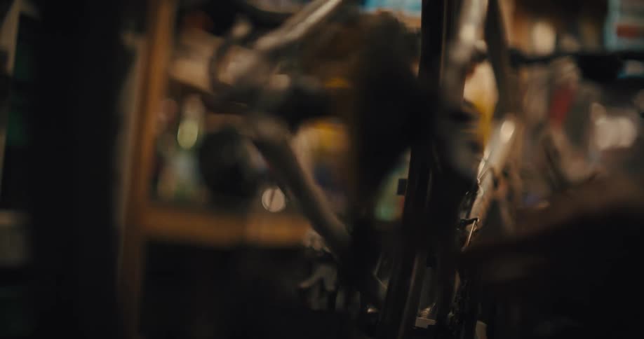 Mechanic uses a screwdriver to adjust a bicycle chain in a workshop
