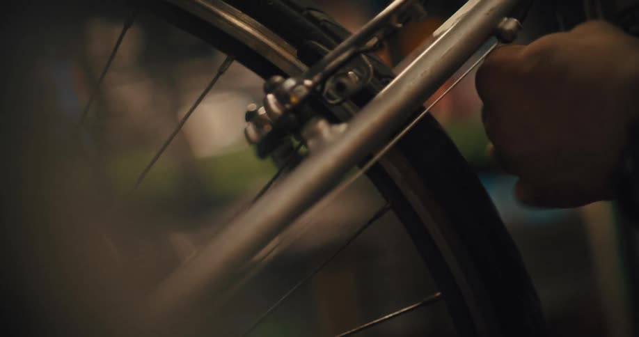 Mechanic holds the bicycle frame while performing a detailed repair