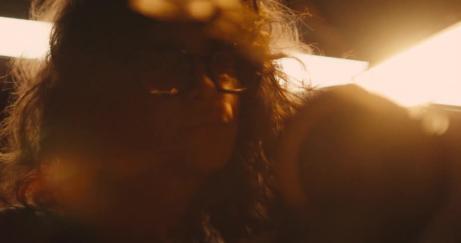 A woman using an angle grinder, sparks fly