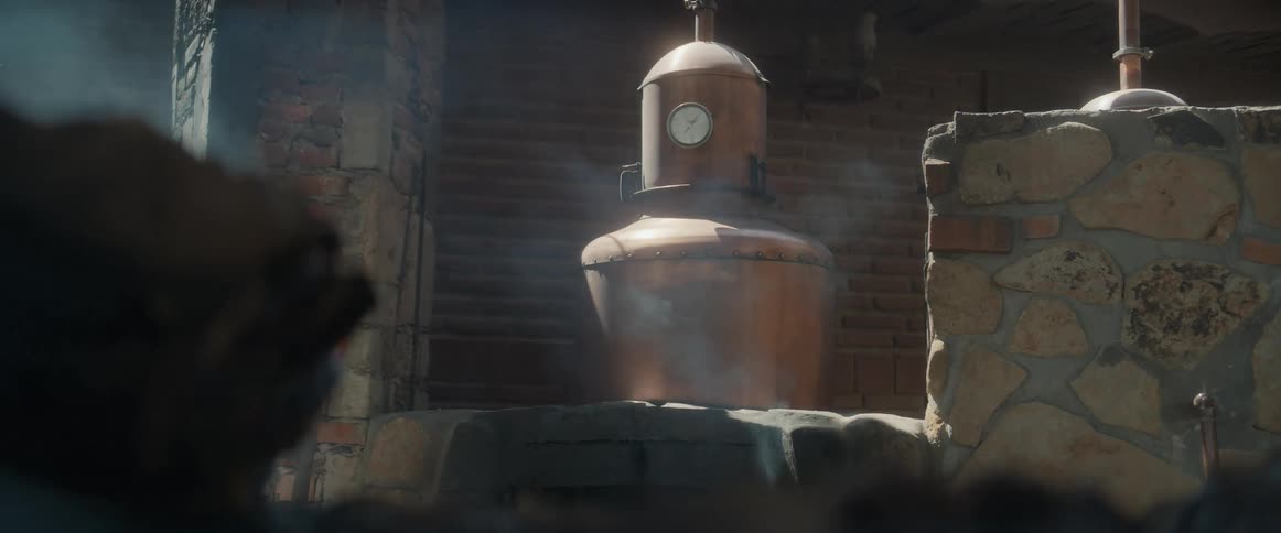 Steam is rising from a still in a room with stone walls