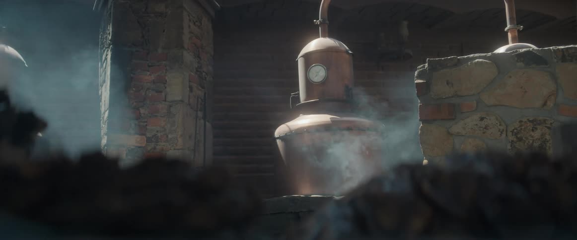 Copper distillation equipment releasing steam between rustic brick and stone walls