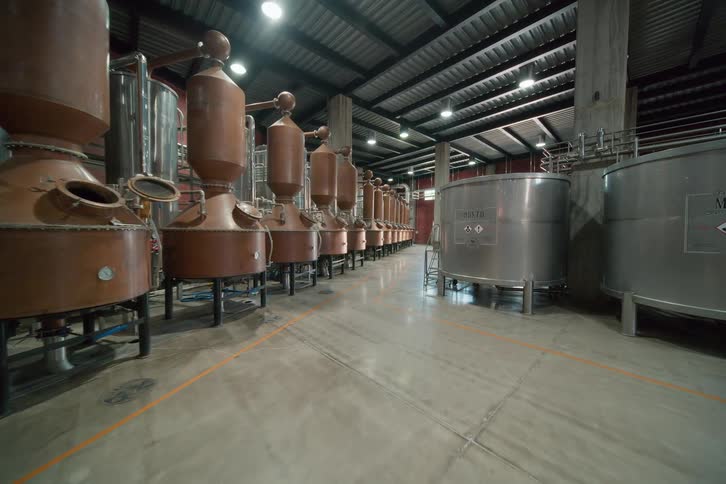 Vats and machines fill a large distillery room