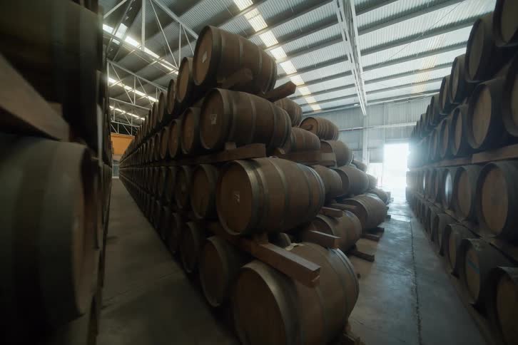 Stacks of barrels are in the warehouse