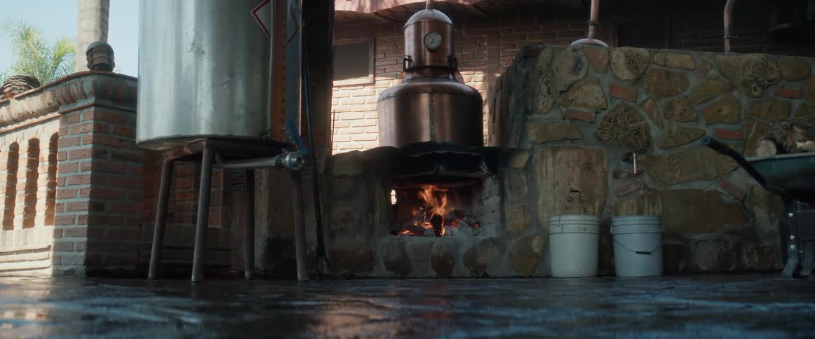 A fire blazes in an outdoor fireplace flanked by a rock wall and a brick wall