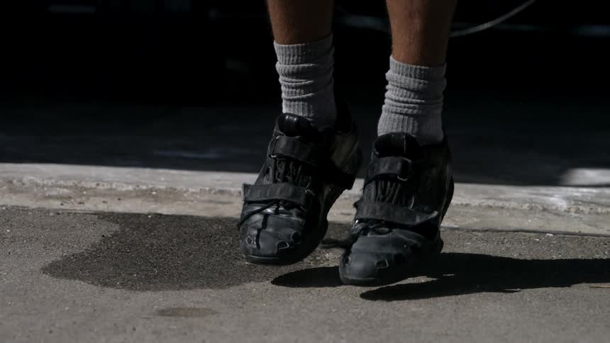 A closeup of a persons feet jumping rope on a gym floor