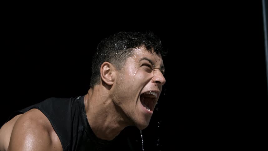 Sweat drips from a mans face as he works out