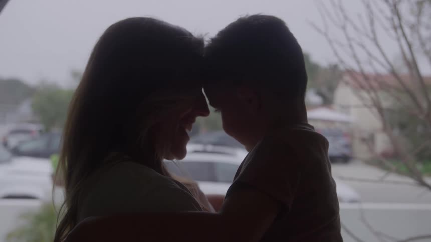 Mother hugging her son and holding him up