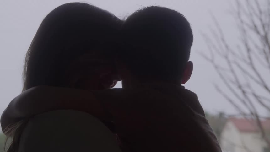 A mother holding her child in her arms with the child hugging her