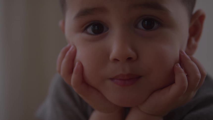 Young boy thinking with his head in his hands