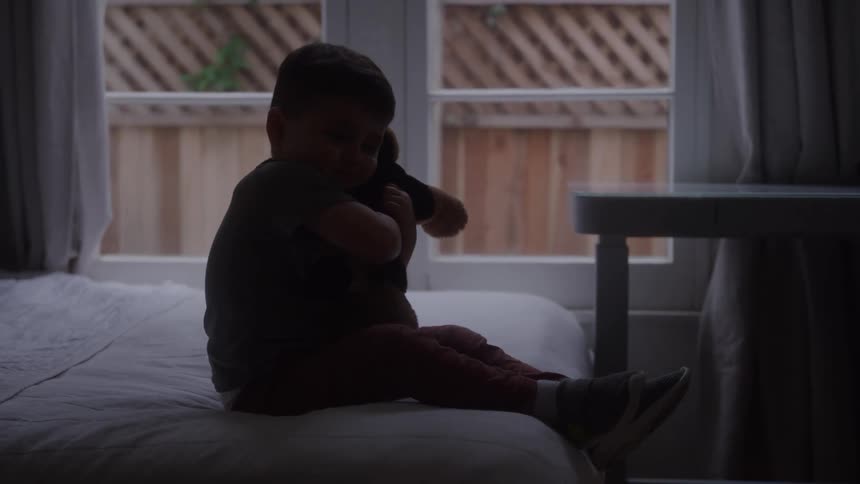 The boy is hugging a stuffed animal
