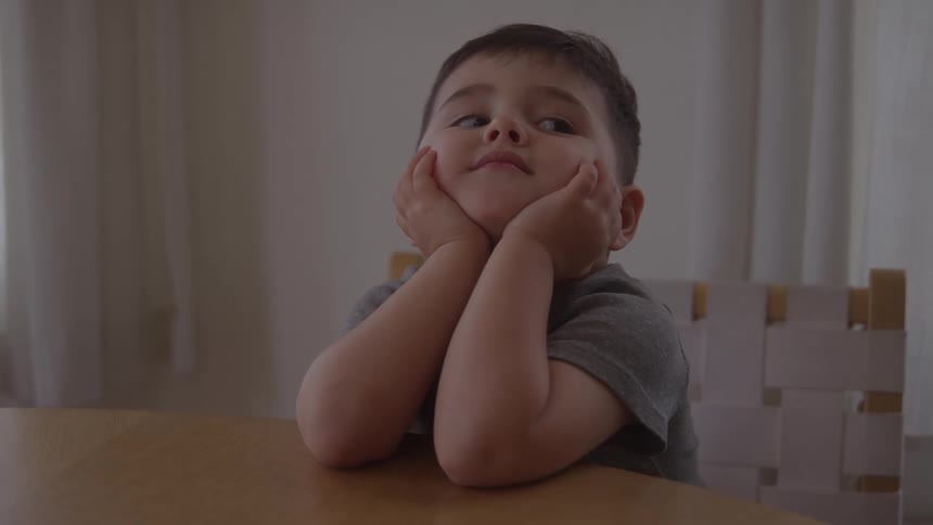 The child is sitting at the table
