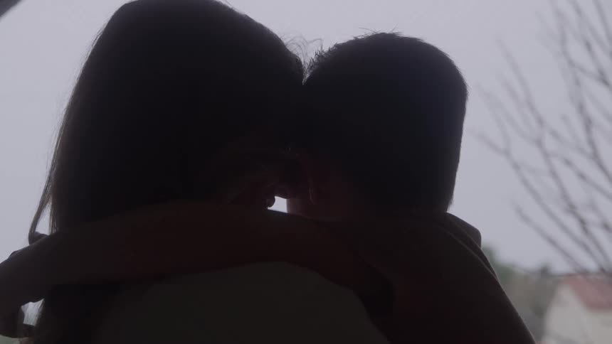 Silhouettes of mother and son embracing in soft light