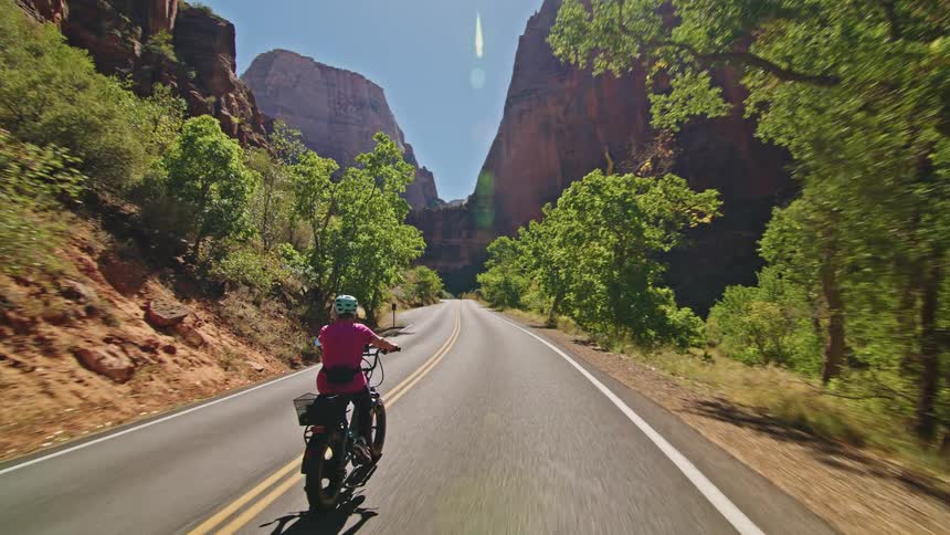 Woman cycling on a mountain canyon road