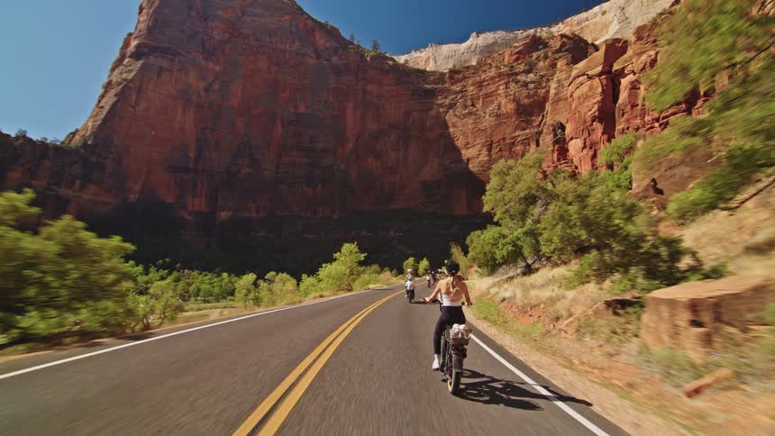 People pedal their bicycles on the mountain road