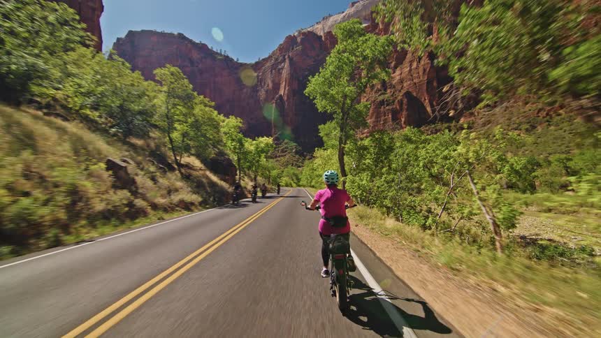 Several people bike along a road