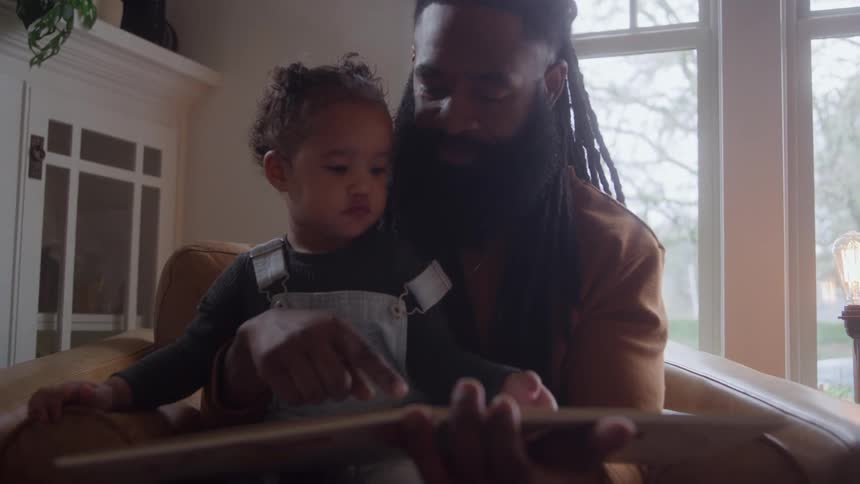 The little girl turns the page in the book