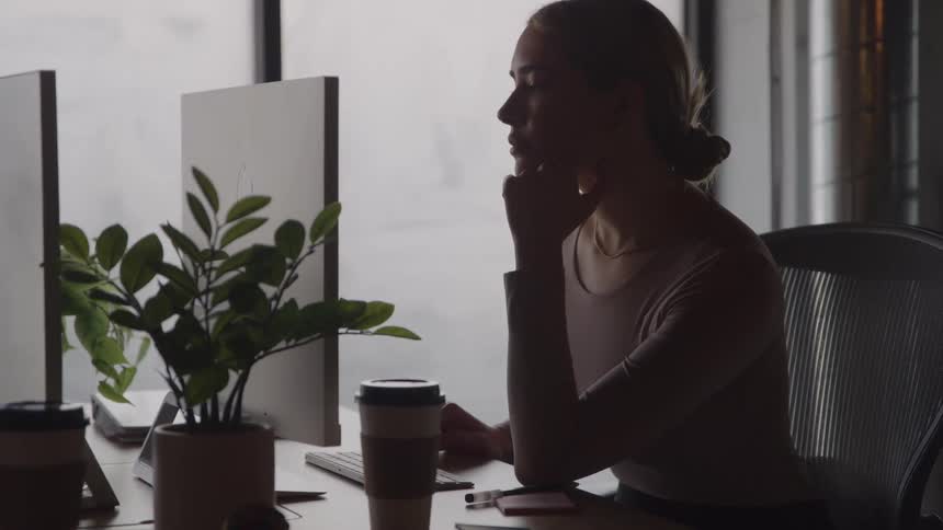 The woman uses her computer in the office