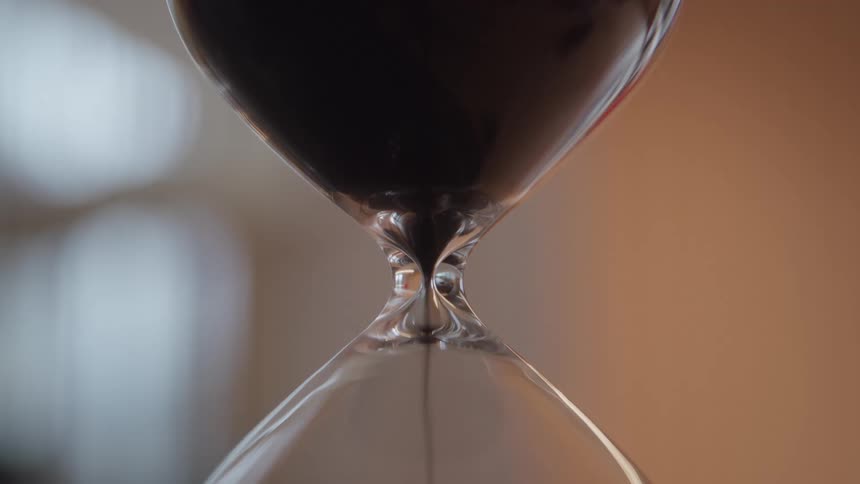 Sand falls inside an hourglass