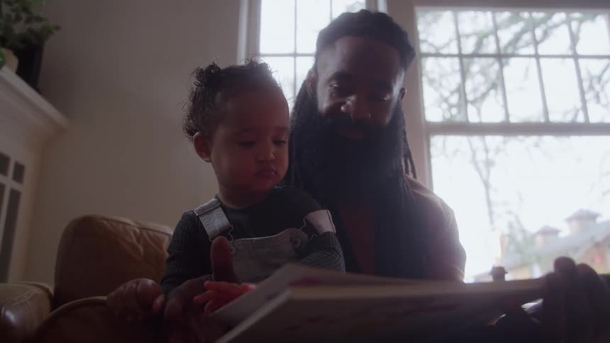 The father and daughter are flipping through a book