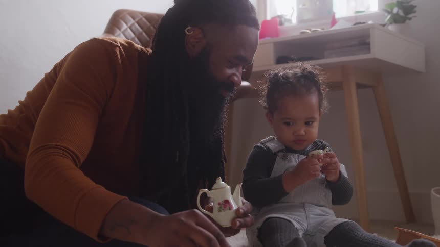 Father and daughter are having a tea party