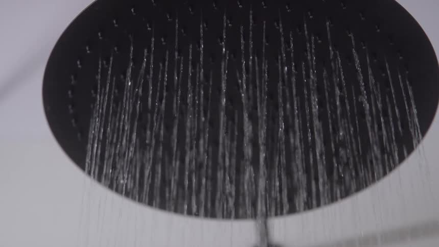 Closeup of water pouring out of a large shower head