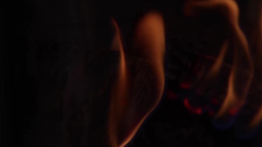 Orange flames flicker gently over the glowing wood