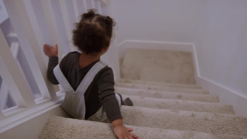 The baby is moving down the stairs