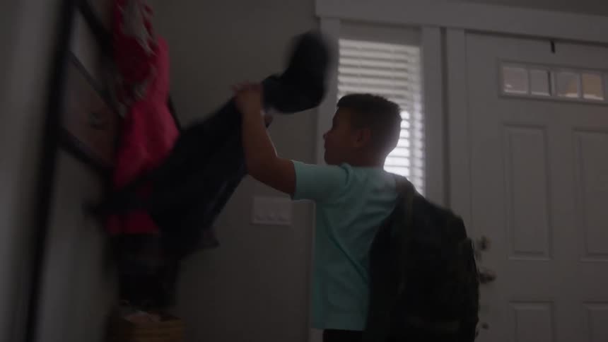 Boy running grabbing a jacket and leaving the house