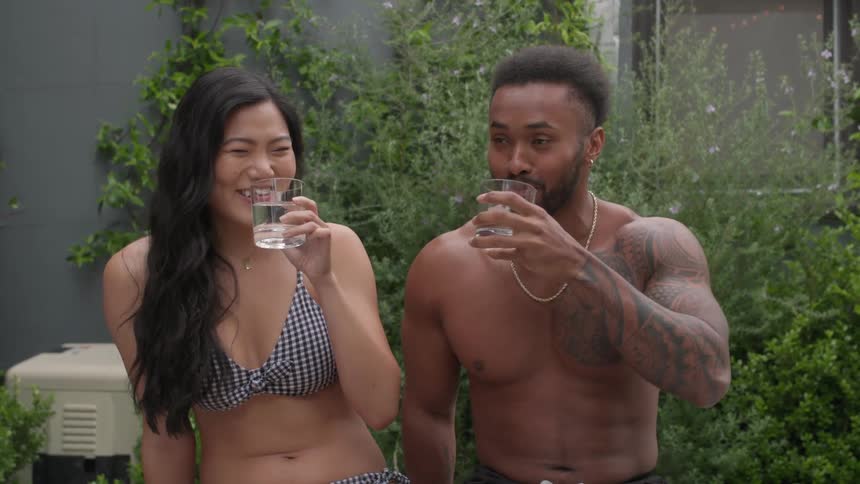 Couple toasts smiling before drinking together outdoors