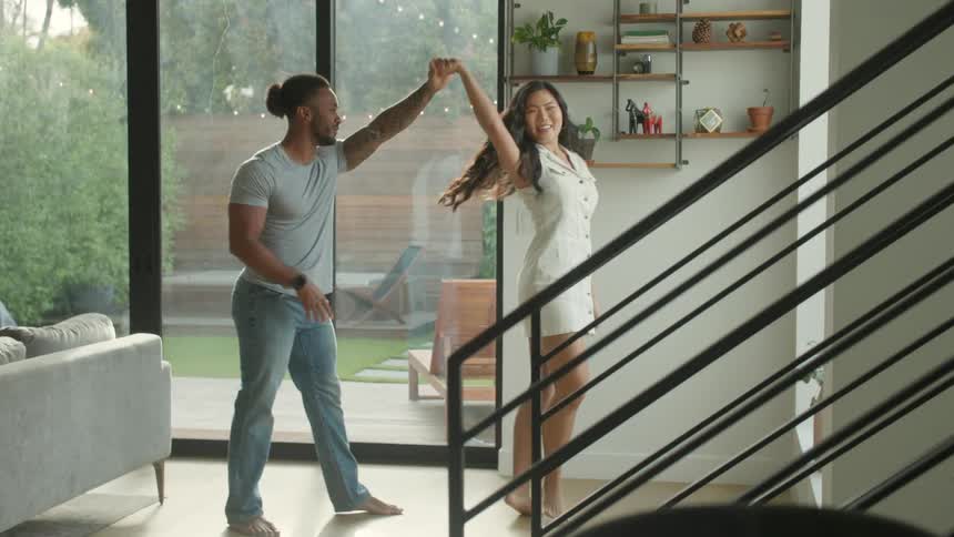 The man and woman dance together at home