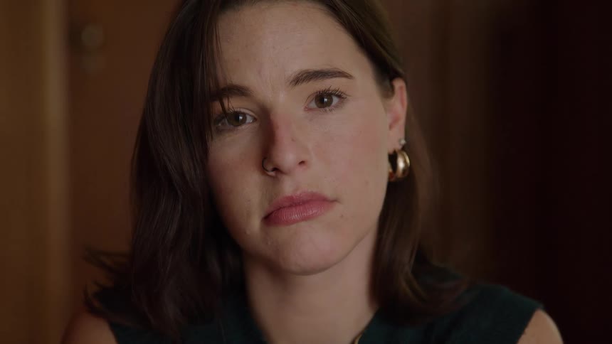 Woman faces calmly in an indoor setting