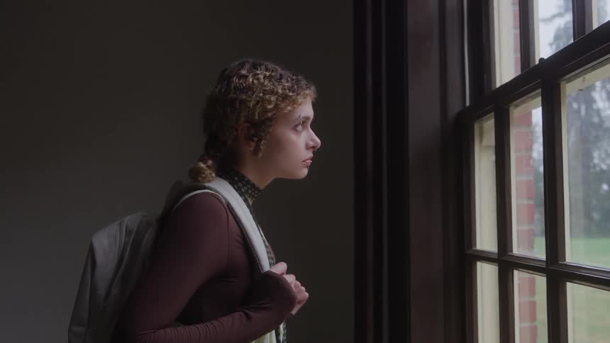 The woman is looking out the window