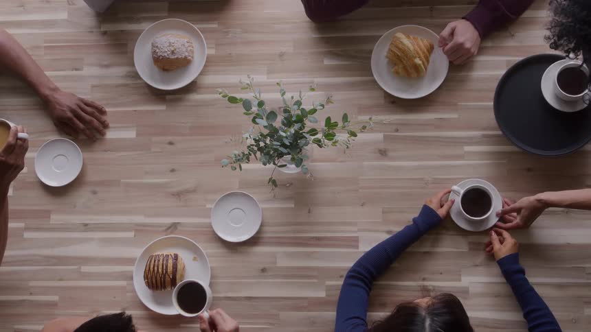 A group of friends eating served desserts at a cafeteria during daytime